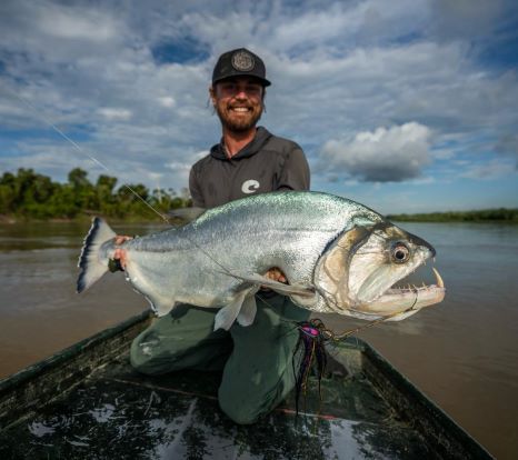 Angler holding a large payara caught on the Payara Dragon Fly in a South American river