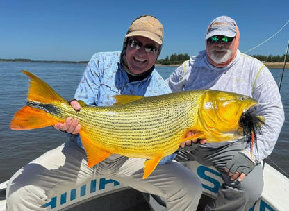 Anglers smilling with a golden dorado caught on the Arapaima Fly Burgundy Head fly