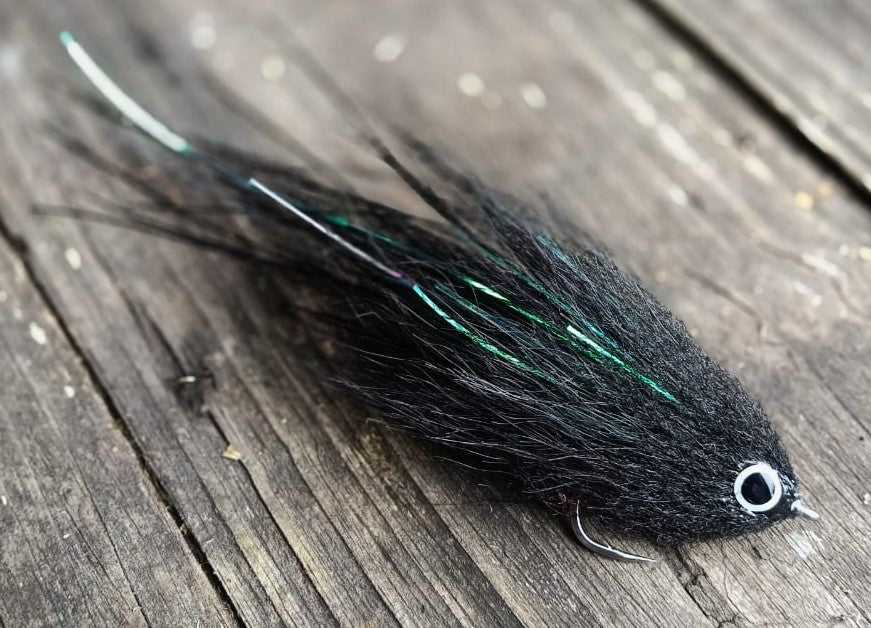Blackened fly, han-tied 6-inch peacock bass streamer in black and white eyes