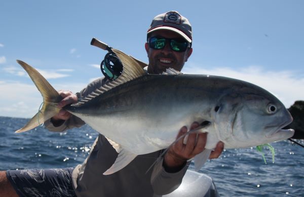 Angler holding a jack crevalle caught on the Chartreuse/White fly in saltwater