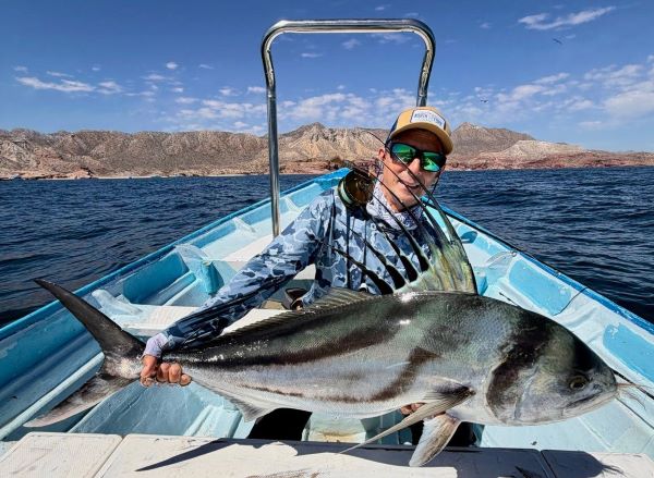 Angler with a beautifull roosterfish caught on the Mullet fly