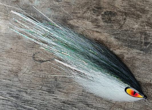 Salton hand-tied Payara Dragon Fly in pale green, white and silver with an orange eye on a wooden background