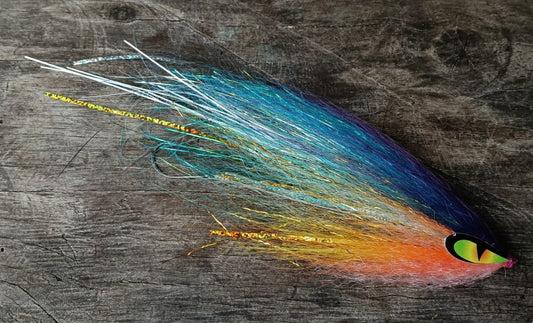 Sardinata hand-tied Payara Dragon Fly in teal blue, orange and pink with a green eye on a dark weathered wood background