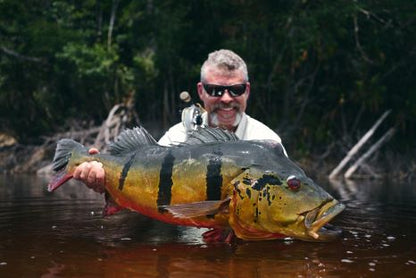 Angler holding a trophy peacock bass caught on the Small Peacock Bass Fly 